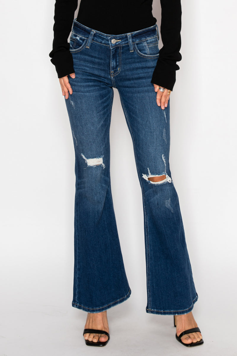 Person wearing blue flared jeans on a white background
